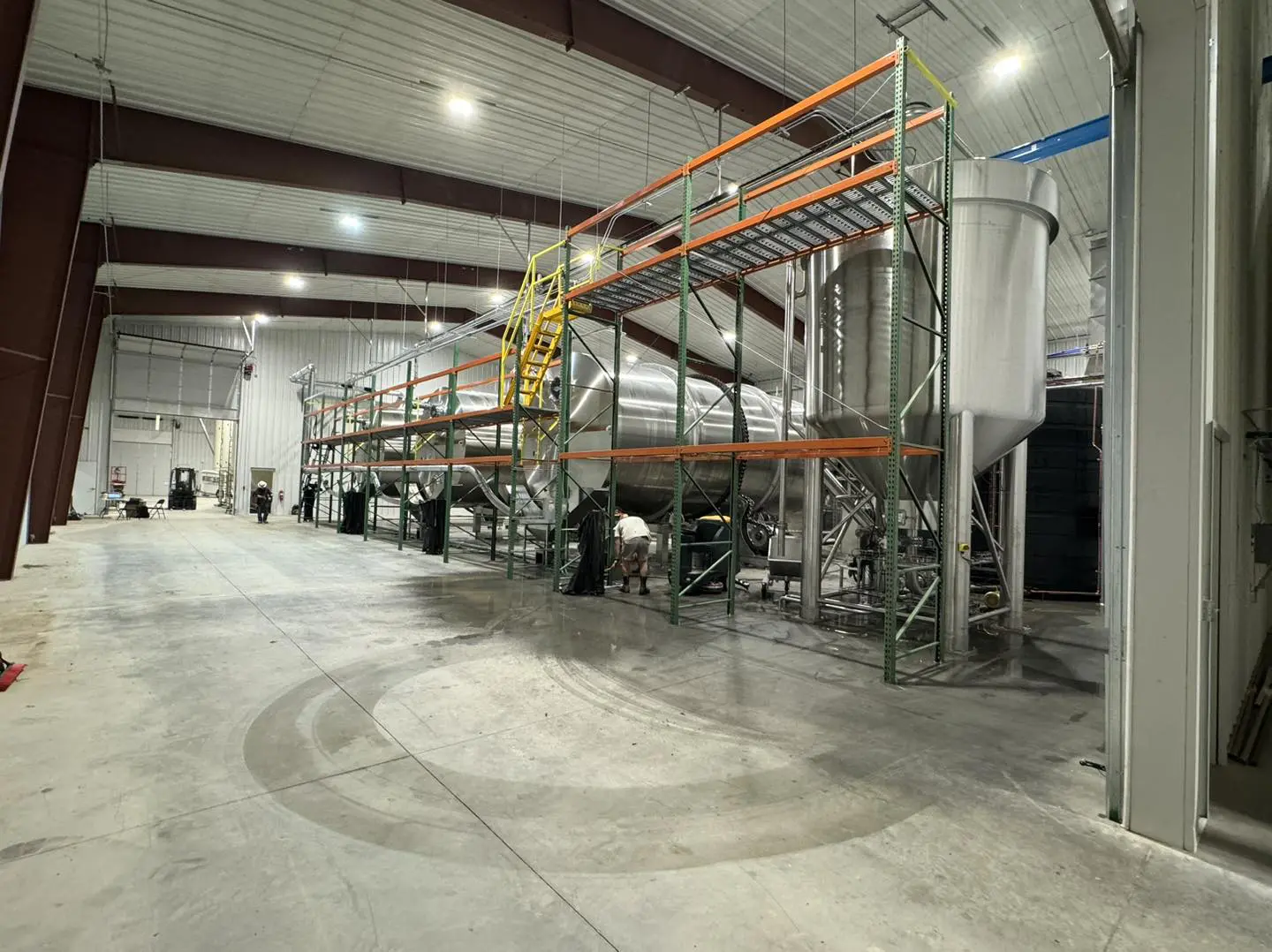 A large warehouse with many metal pipes and shelves.
